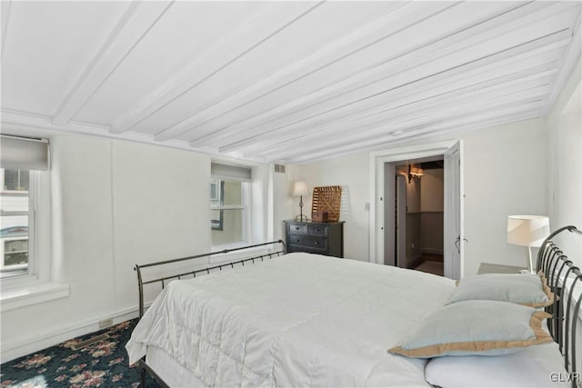 bedroom featuring a walk in closet and beam ceiling