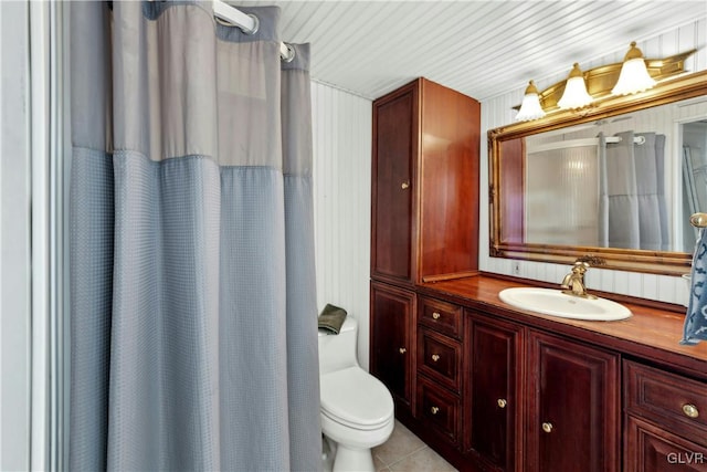 bathroom featuring tile patterned flooring, vanity, curtained shower, and toilet