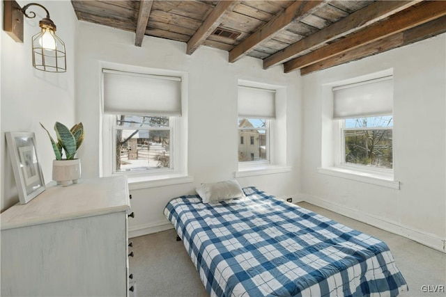 carpeted bedroom with beam ceiling and wood ceiling