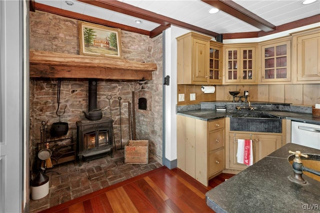 kitchen featuring a wood stove, dark hardwood / wood-style floors, dishwasher, dark stone counters, and beam ceiling