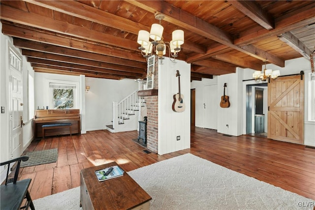 unfurnished living room with a barn door, dark hardwood / wood-style floors, a notable chandelier, and wood ceiling