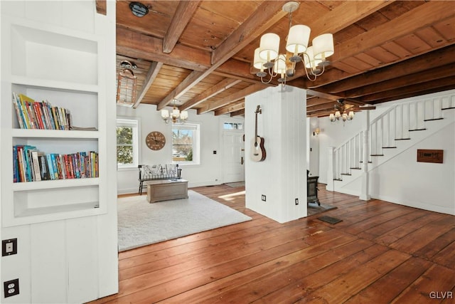 unfurnished dining area featuring built in shelves, wood ceiling, a notable chandelier, beam ceiling, and hardwood / wood-style floors