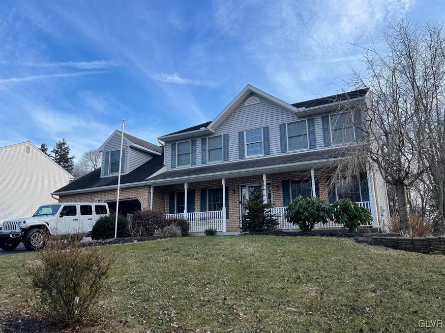 view of front of house with a porch, a garage, and a front yard