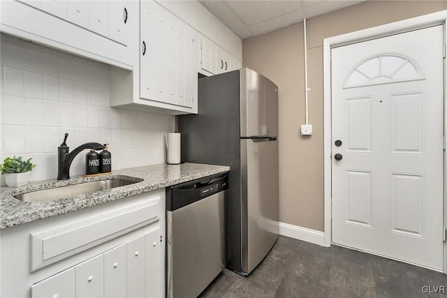 kitchen featuring sink, white cabinetry, a paneled ceiling, tasteful backsplash, and stainless steel dishwasher