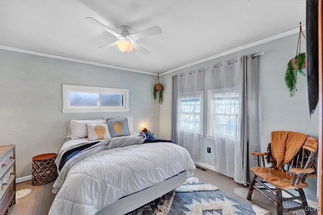 bedroom with crown molding, ceiling fan, and light hardwood / wood-style floors