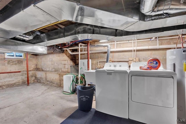 basement with electric water heater and washer and dryer