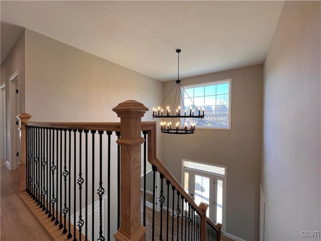 stairway featuring wood-type flooring and a notable chandelier