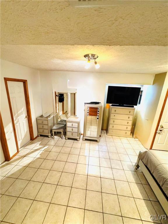 interior space featuring light tile patterned floors and a textured ceiling