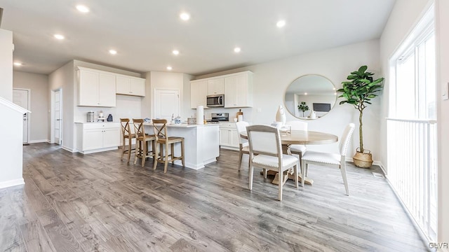 kitchen featuring light hardwood / wood-style floors, stainless steel appliances, an island with sink, and white cabinets