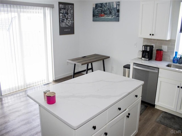 kitchen featuring tasteful backsplash, stainless steel dishwasher, dark wood-type flooring, and white cabinets