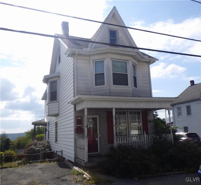 view of front of property with covered porch and a chimney