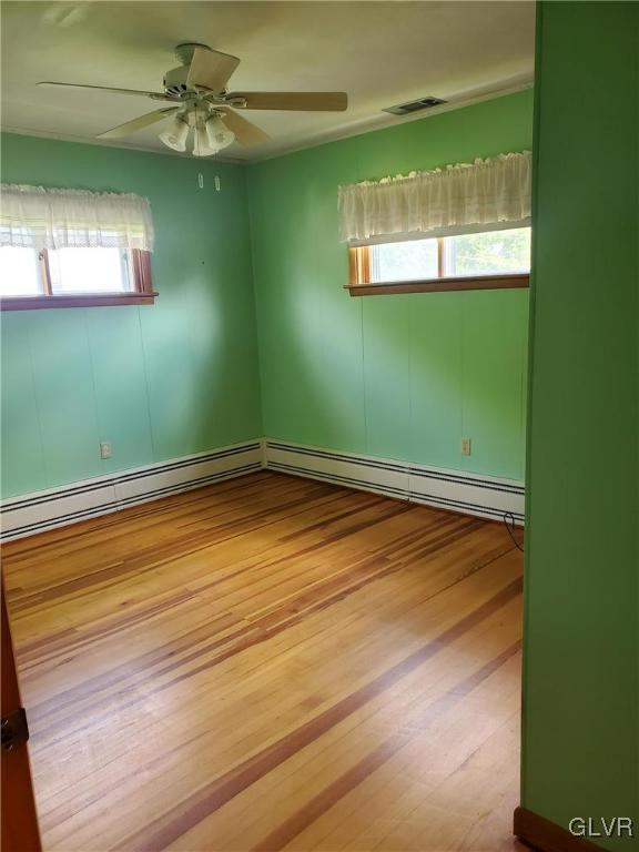 spare room with ceiling fan and light wood-type flooring