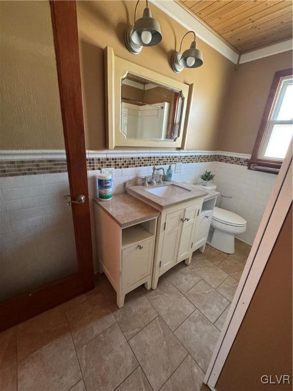 bathroom featuring crown molding, tile walls, vanity, wooden ceiling, and toilet