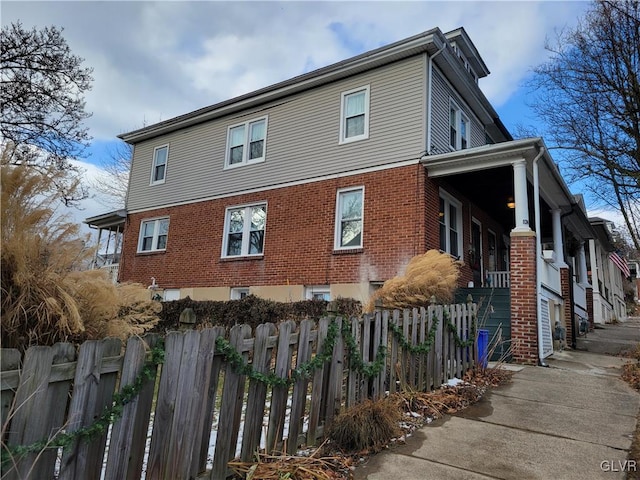 view of home's exterior featuring a fenced front yard and brick siding