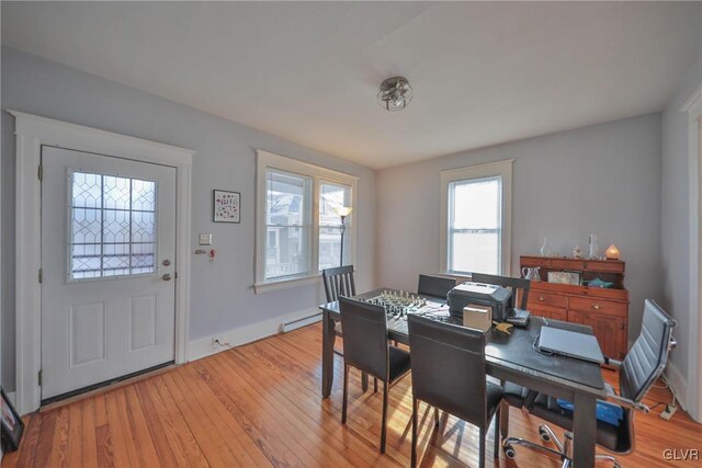 dining space with light hardwood / wood-style floors and baseboard heating