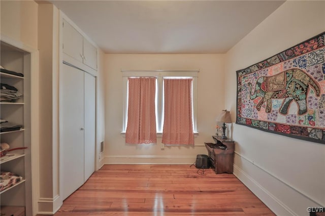 foyer with light wood-style floors, visible vents, and baseboards