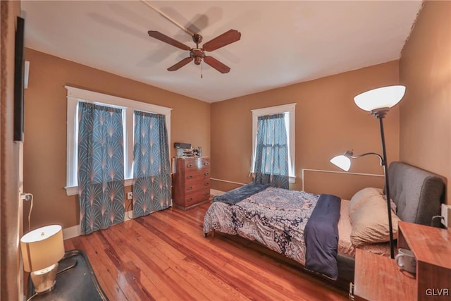 bedroom with baseboards, a ceiling fan, and wood finished floors