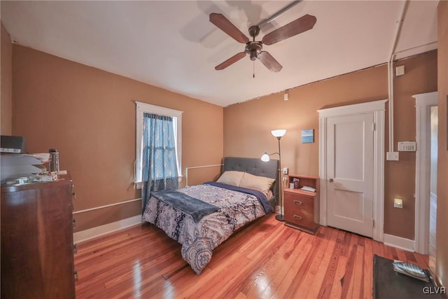 bedroom featuring ceiling fan, wood finished floors, and baseboards