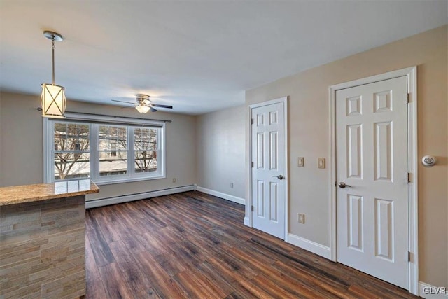 interior space featuring dark hardwood / wood-style flooring, ceiling fan, and baseboard heating