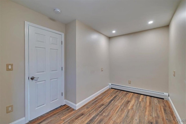 empty room with dark wood-type flooring and baseboard heating