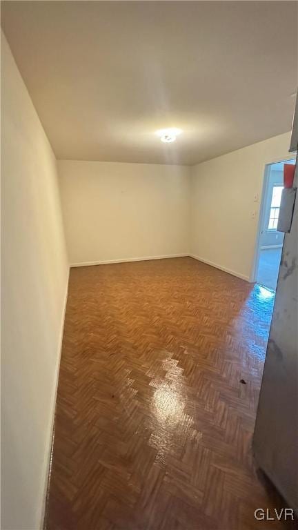 spare room with dark parquet flooring