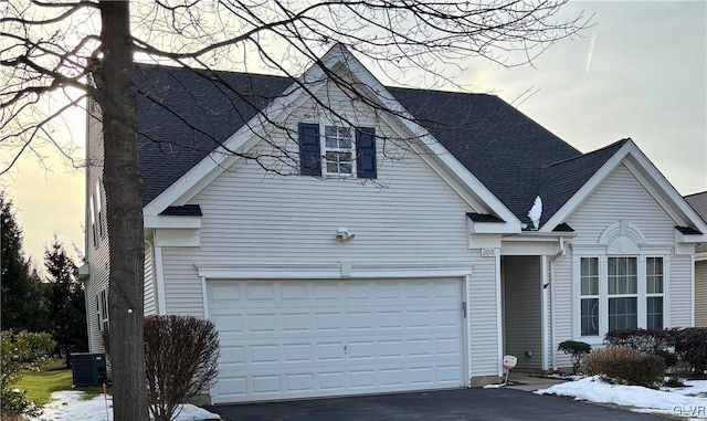 view of front of property with a garage and central air condition unit