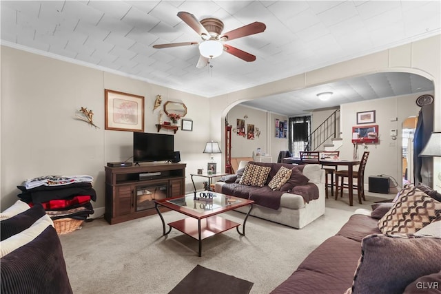 living room with crown molding, light colored carpet, and ceiling fan