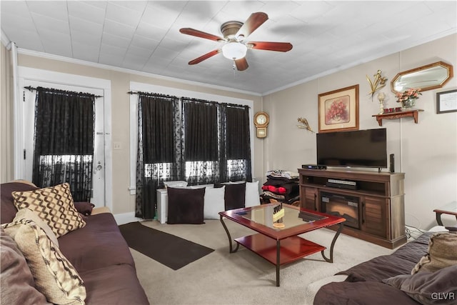 carpeted living room with ornamental molding and ceiling fan