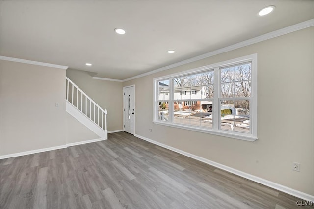 unfurnished living room featuring crown molding and wood-type flooring