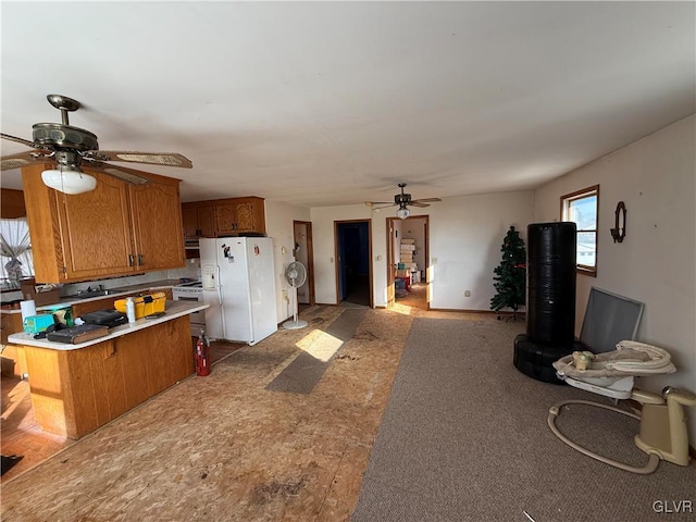 kitchen with ceiling fan, a breakfast bar, white refrigerator with ice dispenser, and kitchen peninsula