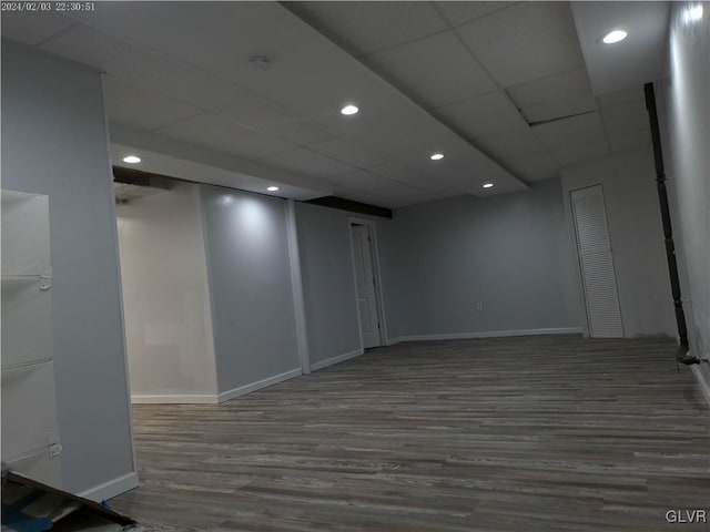 basement with dark hardwood / wood-style floors and a drop ceiling