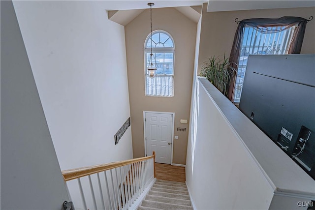 stairs featuring hardwood / wood-style flooring and vaulted ceiling