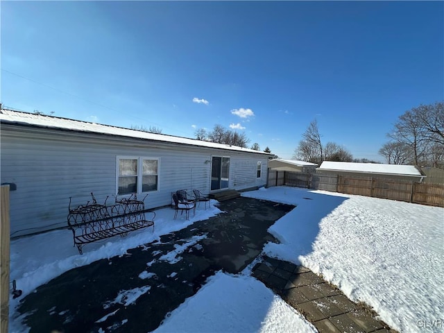 view of snow covered back of property