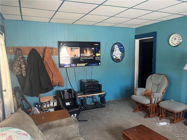 living room featuring carpet and a drop ceiling