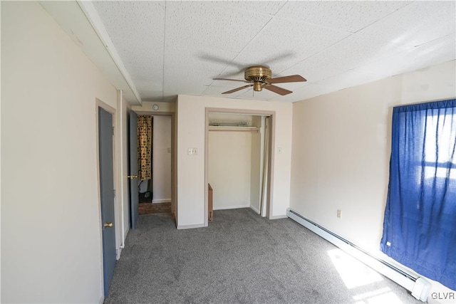 unfurnished bedroom featuring carpet, a closet, ceiling fan, and baseboard heating