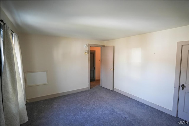 spare room with dark colored carpet