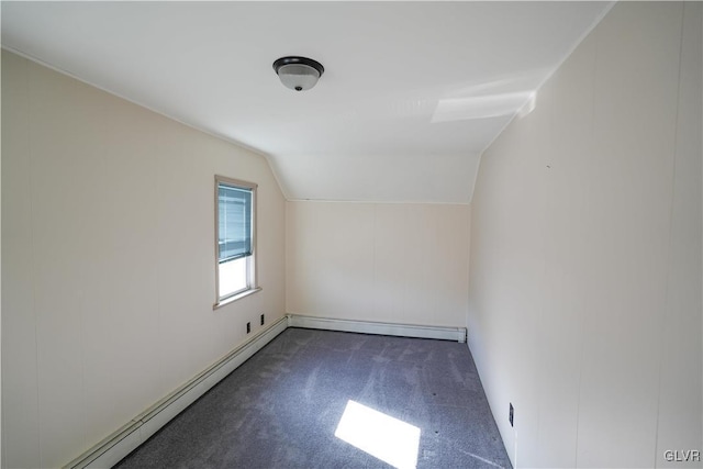 additional living space featuring dark colored carpet, vaulted ceiling, and a baseboard heating unit