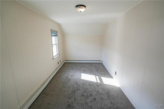 empty room with baseboard heating, lofted ceiling, and dark carpet