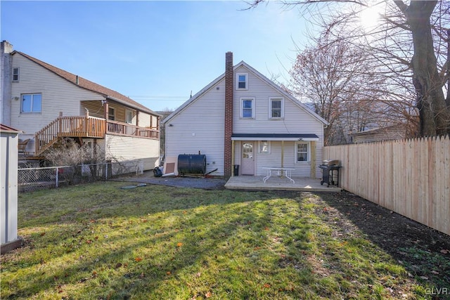 back of property with a lawn and a patio