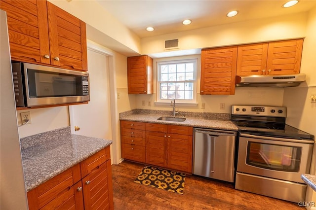 kitchen with light stone counters, stainless steel appliances, dark hardwood / wood-style flooring, and sink