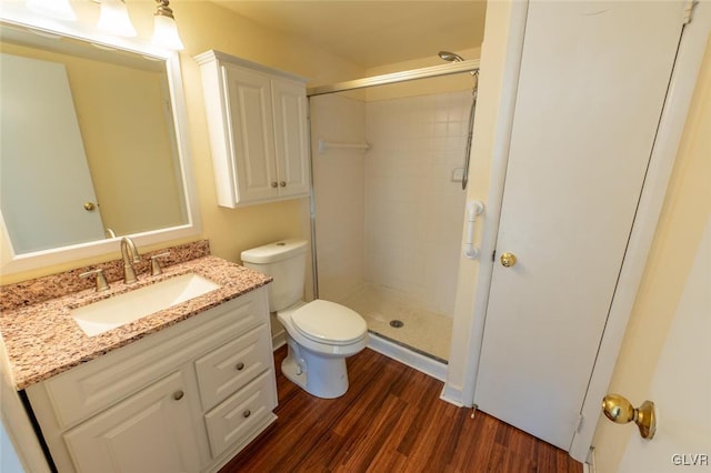 bathroom featuring hardwood / wood-style flooring, vanity, toilet, and a shower with shower door