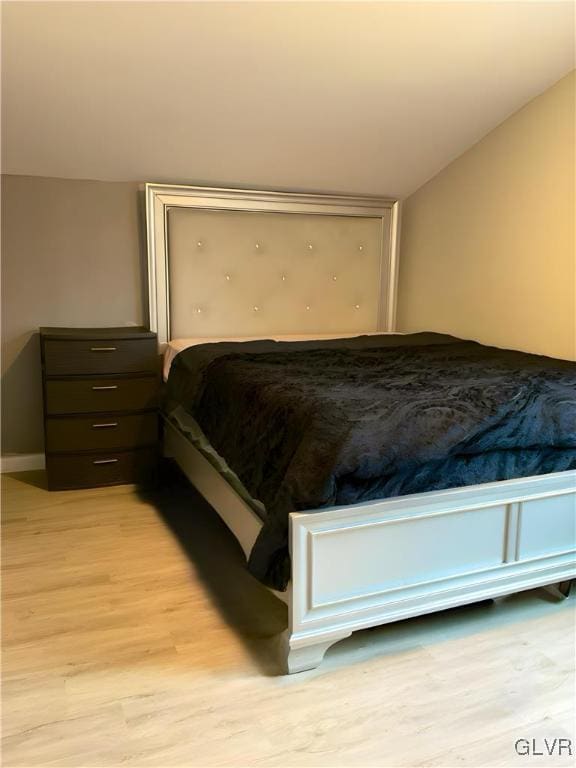 bedroom featuring vaulted ceiling and light wood-style floors