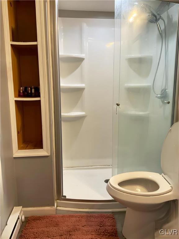 bathroom with a stall shower, a baseboard radiator, and toilet