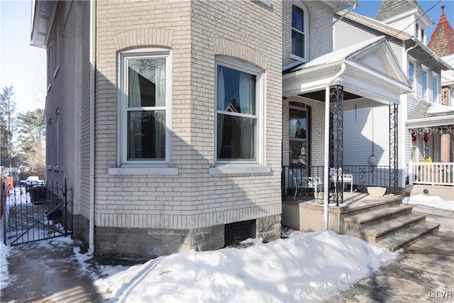 view of snow covered exterior featuring covered porch