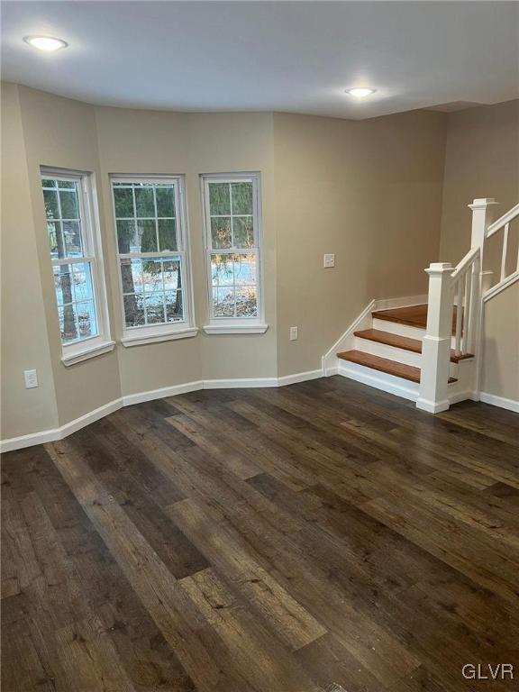 unfurnished room with a healthy amount of sunlight and dark hardwood / wood-style floors