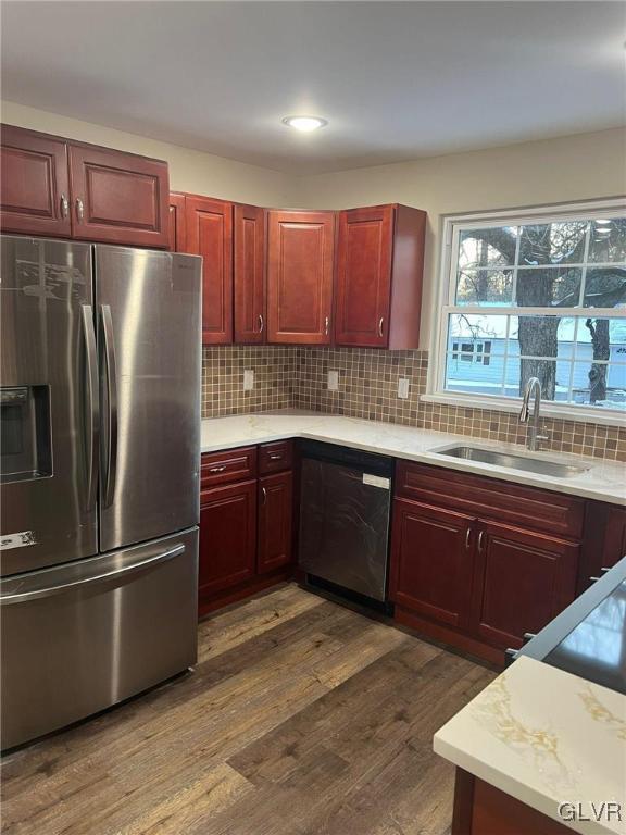 kitchen with stainless steel appliances, sink, dark hardwood / wood-style floors, and decorative backsplash