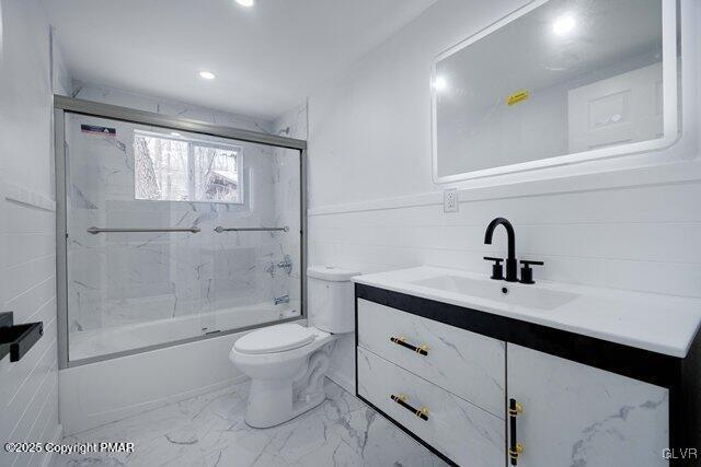 full bathroom featuring bath / shower combo with glass door, vanity, and toilet