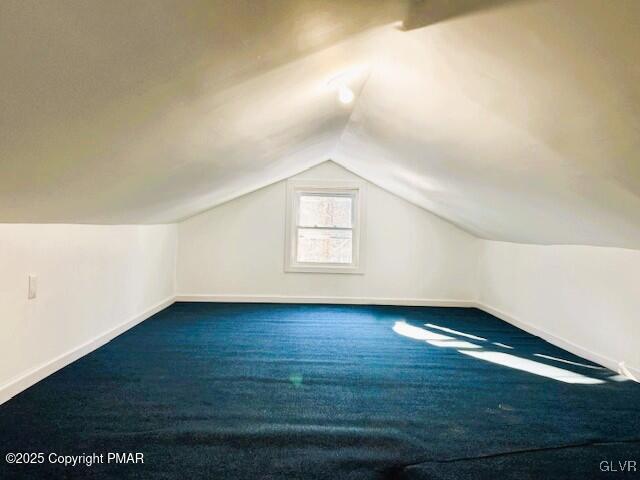 bonus room with lofted ceiling and carpet flooring