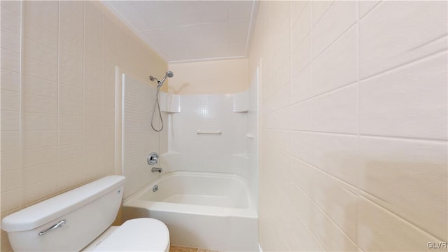 bathroom featuring shower / washtub combination, tile walls, and toilet