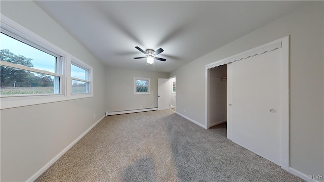 unfurnished bedroom featuring a baseboard radiator, light colored carpet, a closet, and ceiling fan